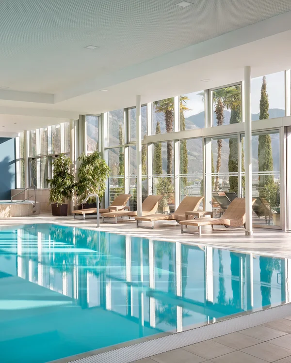 Moderner Innenpool mit großen Fenstern und Liegestühlen